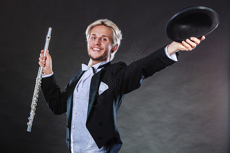 古典音乐激情和业余爱好概念穿着优美服装的音乐家戴黑帽子的长笛男深底背景的演播室拍摄穿着优美服装的音乐家持长笛图片