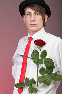 有红玫瑰的年轻人穿着彩色背景爱与反射图片