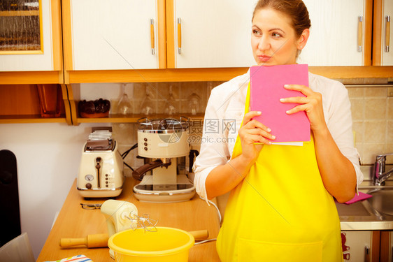 家庭主妇计划晚饭中年女厨师在房做饭图片