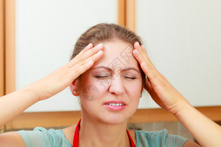 患有头痛和偏头痛的妇女紧张的女患有头痛和偏头痛的妇女背景图片
