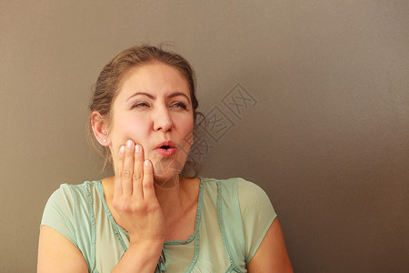 痛和的概念女人有坏的痛和女人用手掌从外面抚摸她的嘴时感觉到牙痛女人感疼图片