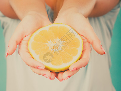 女手上一半的黄葡萄果柑橘水健康饮食体重减值概念图片