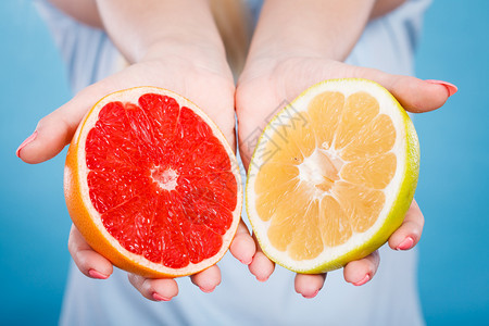 女手掌中的黄果和红葡萄柑橘水果一半女口腔卫生员建议健康饮食营养人手中的黄红葡萄柑橘水果一半图片