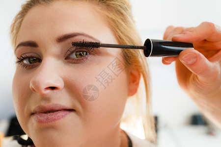 近视镜美容概念女脸部的近视肖像由专业艺术家用马斯卡拉做眼睫毛化妆背景图片