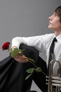 一个年轻的爵士人和Trumpet灰色背景的肖像爱情旋律背景图片