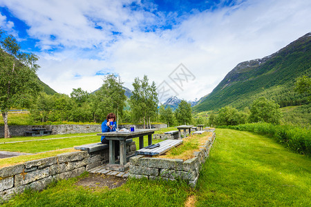 在斯堪的纳维亚欧洲诺韦吉山区旅行妇女吃大自然的午餐在挪威山区旅行妇女吃大自然的午餐图片