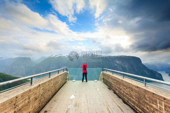 旅游业和旅游业挪威斯堪的纳维亚半岛Stegasteinlookout的女自然旅游摄影师正在用相机拍照欣赏奥兰峡湾风景挪威Steg图片