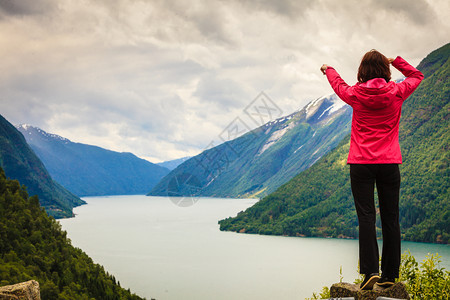 旅行概念游女客对挪威美丽的山地风景fjordsfjords用手指看和着图片