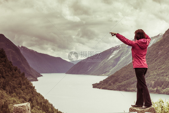 旅行概念游女客对挪威美丽的山地风景fjordsfjords用手指看和着图片