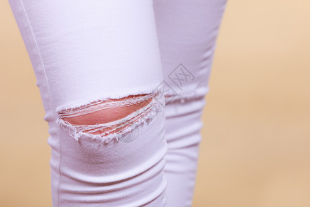 时装和当前趋势概念详细缝紧白妇女裤子膝上穿洞缝紧白妇女裤子膝上穿洞图片