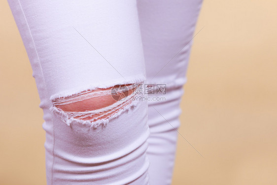 时装和当前趋势概念详细缝紧白妇女裤子膝上穿洞缝紧白妇女裤子膝上穿洞图片