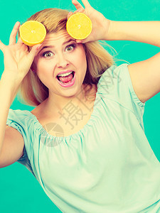 怀着两半黄柠檬柑橘水果的少女手握两半黄柠檬柑橘水果吃着深绿色营养健康饮食图片