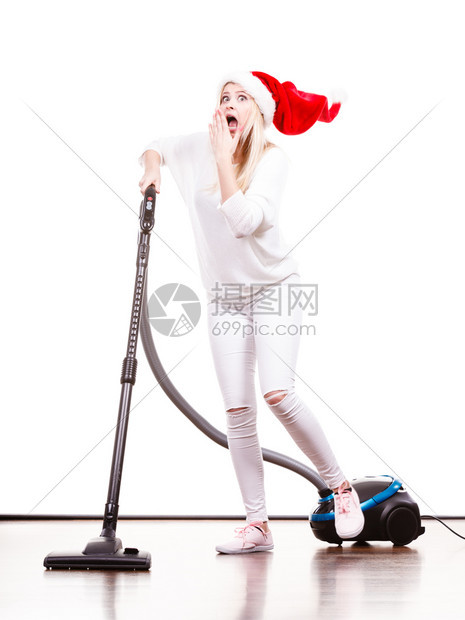 女人在屋内吸尘女孩在圣塔帮手的帽子里与吸尘器清洁工一起有趣的少女圣诞节时间和家务概念女孩与吸尘器清洁工一起在圣塔帮手的帽子里在圣图片