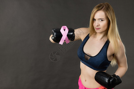 身戴带粉色丝的拳击手套乳癌符号与疾病作斗争女动机工作室在黑暗背景中拍摄身着粉色丝带的拳击手套身着粉色丝带的妇女身着拳击手套的妇女图片
