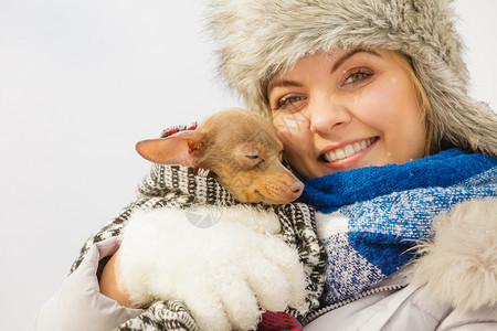 年轻女用温暖的毛毯围巾裹住她最好的朋友小狗在寒冷的冬天温暖他动物保护存收养概念妇女拥抱在寒冷的一天温暖她狗图片