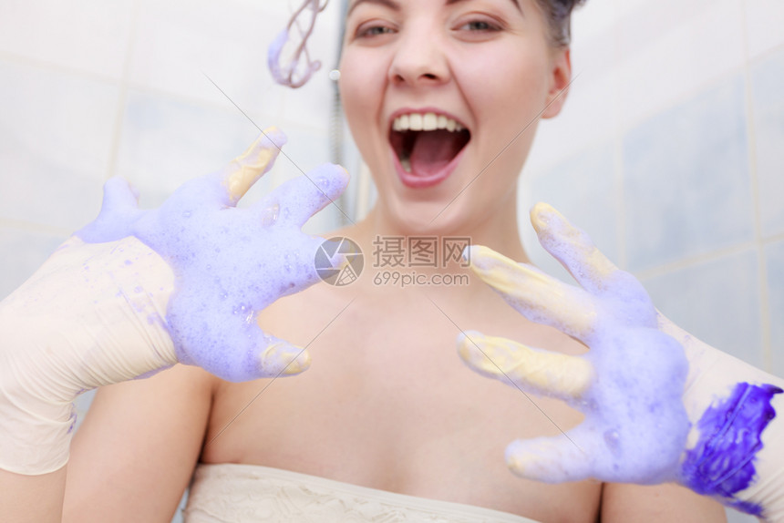 有趣的疯女人头发上染着香波紫色洗发品在家里把金色调成有趣的女人头发上沾着调味香波图片