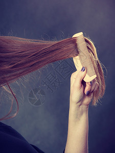健康的外观概念女孩用木梳理头发年轻女照顾日常卫生和自然美貌长发女梳理头图片
