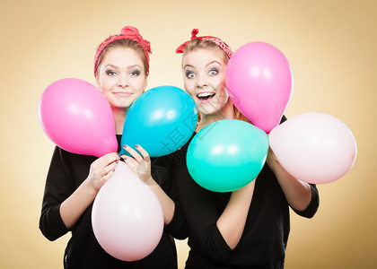 准备生日派对两位快乐的年轻女孩准备庆祝带着多色气球微笑的快乐女人图片