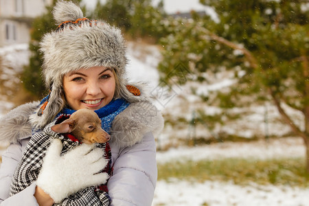 年轻女用毛毯围巾裹住她最好的朋友小狗在寒冷的冬季天温暖他动物保护存收养概念冬天女拥抱温暖她的小狗图片