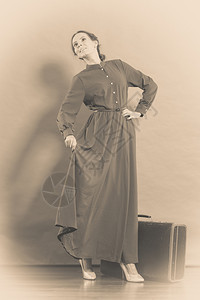 女人的旧式长的深色袍旧式手提箱照片塞皮亚图片