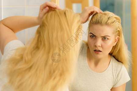 金发女人在洗手间里看着自己身上有油的头发有问题皮抓伤自己脱衣问题金发女人有问题头发图片