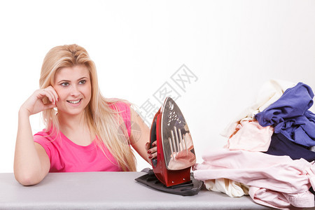 做家务照顾衣服概念快乐的女士站在船身后面衣着堆积如铁快乐的女士做熨衣服图片
