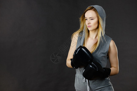戴头罩的年轻女子打拳击金发美女戴黑色拳击手套运动和健身权力锻炼穿灰色拳击女运动员用手套锻炼图片