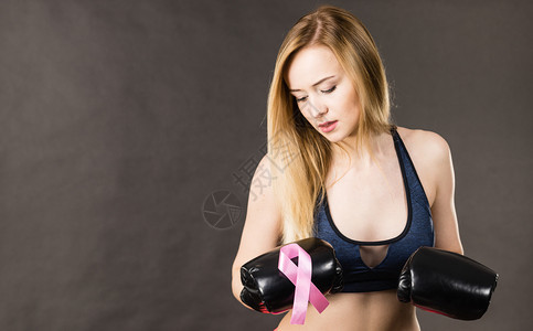 身戴带粉色丝的拳击手套乳癌符号与疾病作斗争女动机工作室在黑暗背景中拍摄身着粉色丝带的拳击手套身着粉色丝带的妇女身着拳击手套的妇女图片