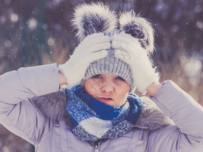 年轻美女在冬季穿着温暖的首饰女穿着灰色的豆热帽有蓬和粉红色夹克女穿着温暖的服装图片