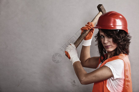 男女平等和权主义戴安全头盔的穿橙色背心感女孩拿着锤子工具有吸引力的妇女从事建筑工人作图片