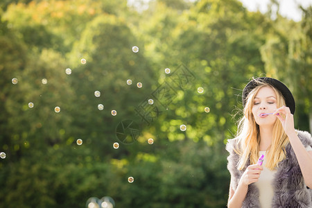 有趣的年轻时尚髦女青年在户外吹香皂泡玩得开心欢乐的少女人吹泡图片