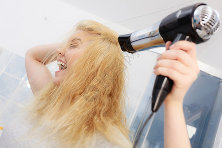 阳女人在金发头上用烘机理概念金女人用吹机背景图片