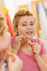 干燕窝面部干皮肤和身体护理在家治疗肤色的概念从脸上剥凝胶面膜的女人从脸上剥凝胶面膜的女人背景