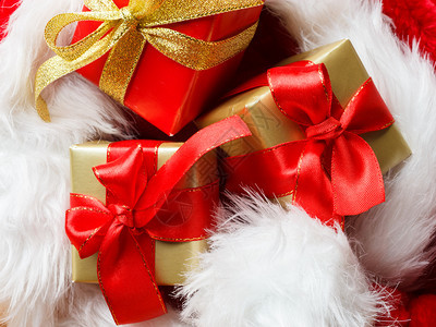 节日现圣诞节概念小盒装着礼物红背景上绑着弓图片