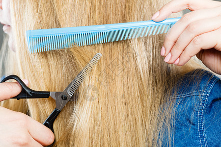 剪裁和概念金发女郎剪裁和梳理她那直滑的光发型专业家制作新的柔软发型女人剪裁光滑的发型图片