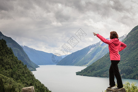 旅行概念游女客对挪威美丽的山地风景fjordsfjords用手指看和着图片