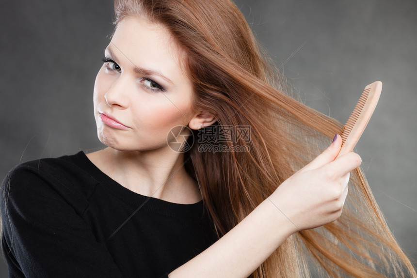 美女梳她长的光滑健康头发然后出去派对和庆祝的概念长发女孩梳她的