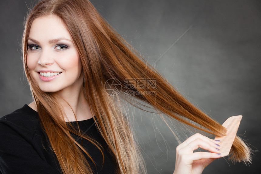 美女梳她长的光滑健康头发然后出去派对和庆祝的概念长发女孩梳她的