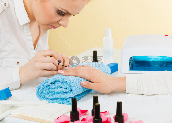 职业和工作美容健康概念年轻女美容师为客户做指甲美容师注重完结果容师做指甲图片