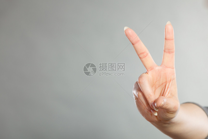 女手举两只指作为胜利的象征良好感觉和积极胜利情绪女手举着胜利象征图片
