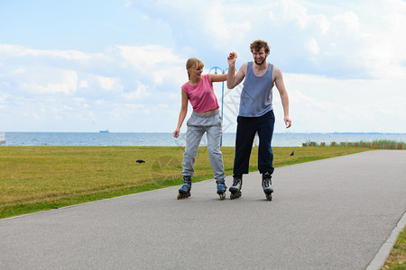 活跃的节日锻炼关系概念年轻男女穿着运动式的服装手握双在赛道上拉着滚轮图片