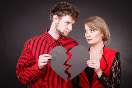 心碎难恋的概念伤心不幸福的夫妻男女手拿纸红心用石膏绷带固定关系裂痕伤心的夫妻抱着破碎的心图片