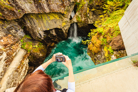 挪威的旅游景点欧洲摄影女师在瓜德勃朗斯朱韦特瀑布上拍摄照片在瓦尔达和特罗斯提根之间的瓦尔达林谷图片