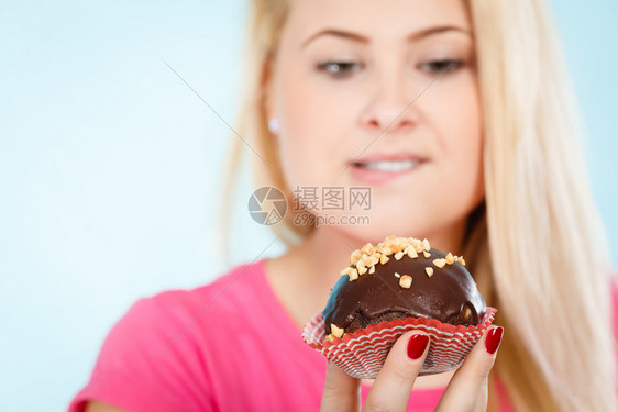 女人拿着美味巧克力蛋糕花生糖霜快咬了女人拿着巧克力蛋糕要咬了图片