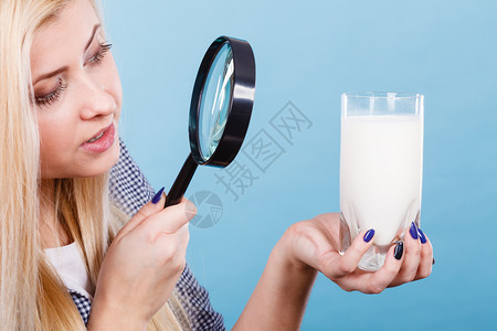 健康饮料良好的营养奶制品成分概念妇女通过放大玻璃看牛奶图片