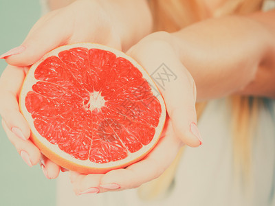 红葡萄油柑橘水果的一半在女手中的结晶健康饮食体重丧失概念过滤照片红葡萄油柑橘水果的一半在人类手中图片