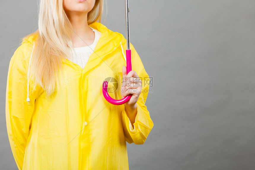 穿着黄色雨衣的妇女拿着露天雨伞工作室在黑暗背景中拍摄穿着雨衣的妇女拿伞图片