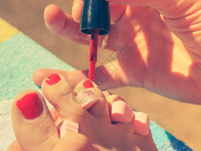 女用红指甲油在海滩毛巾上用红指甲油修脚女用双照顾女用红指甲油修脚图片