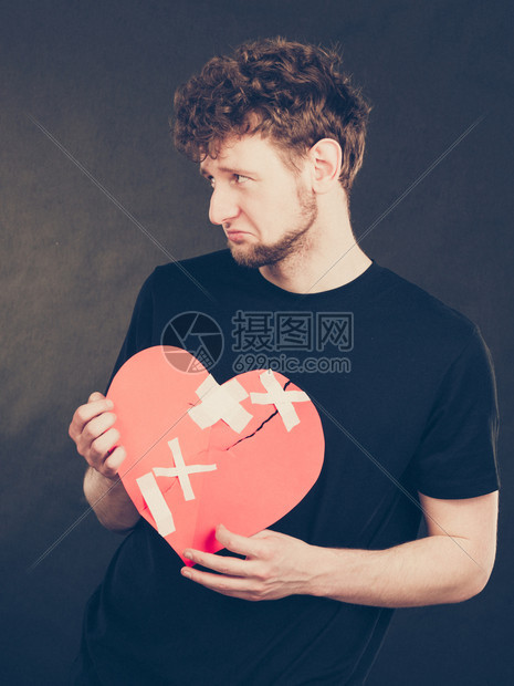 悲伤的年轻男人被石膏粘住的红心失去爱情人节图片