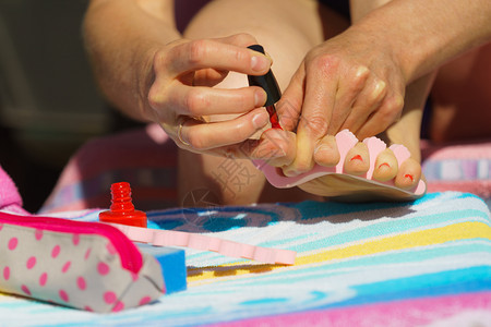 女用红指甲油在海滩毛巾上用红指甲油修脚女用双照顾女用红指甲油修脚图片